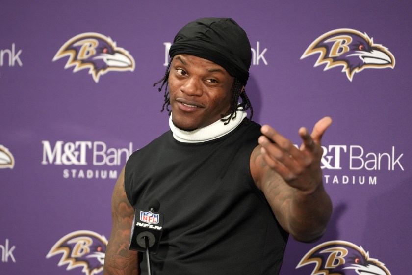 Lamar Jackson points to someone during a press conference.