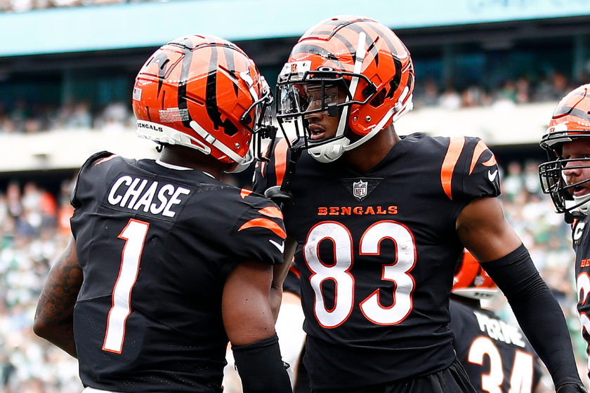 Tyler Boyd #83 of the Cincinnati Bengals celebrates with Ja'Marr Chase #1 (L) and Ted Karras #64 (R) after a catch for a touchdown