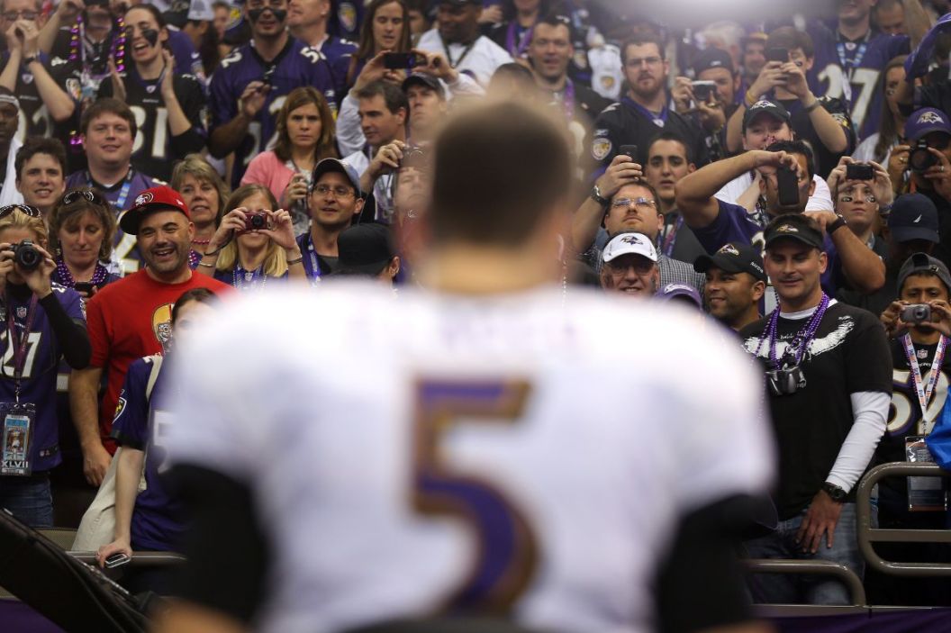 Baltimore Ravens fans look on as Joe Flacco #5 is interviewed after defeating the San Francisco 49ers during Super Bowl XLVII