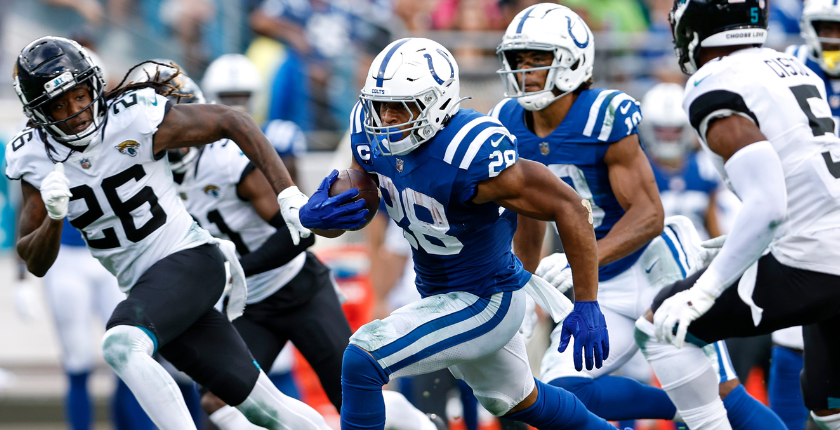 Runningback Jonathan Taylor #28 of the Indianapolis Colts avoids getting tackled by Cornerback Shaquill Griffin #26 and Safety Andre Cisco #5 of the Jacksonville Jaguars on a running play