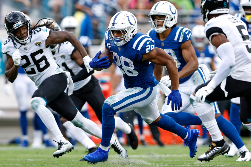 Runningback Jonathan Taylor #28 of the Indianapolis Colts avoids getting tackled by Cornerback Shaquill Griffin #26 and Safety Andre Cisco #5 of the Jacksonville Jaguars on a running play
