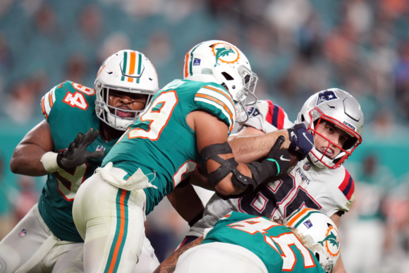Hunter Henry of the New England Patriots is tackled by the defense of the Miami Dolphins