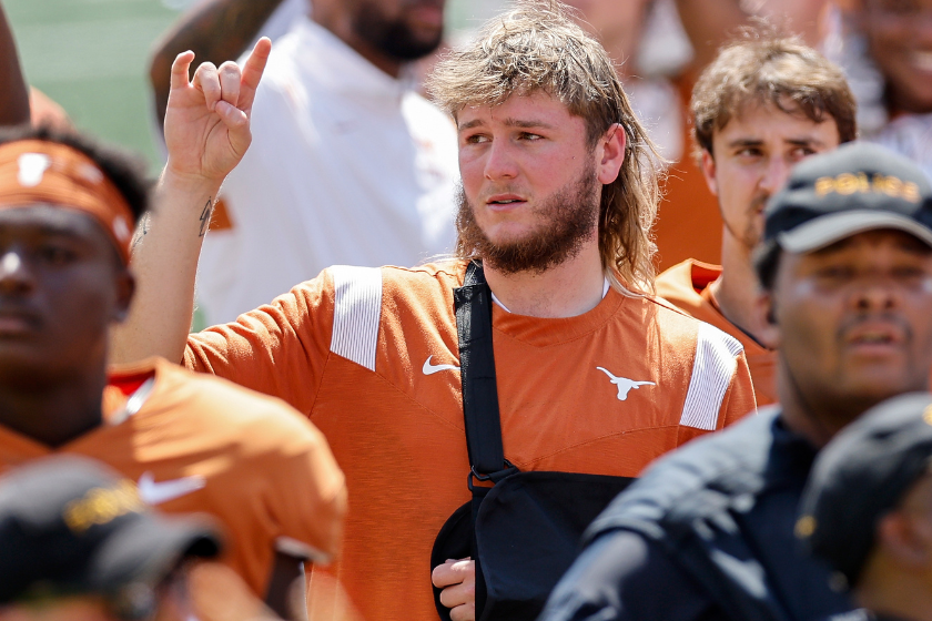 Quinn Ewers #3 of the Texas Longhorns sings The Eyes of Texas while wearing a sling on his left arm
