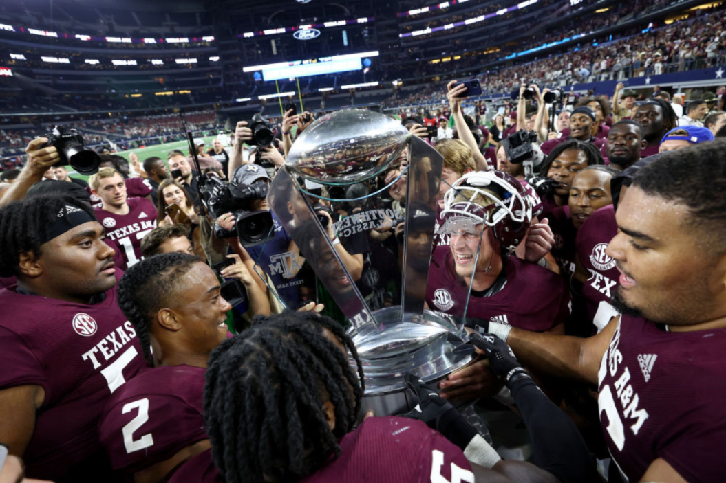 The Texas A&M Aggies celebrate with the game trophy after beating the Arkansas Razorbacks 23-21 in the 2022 Southwest Classic