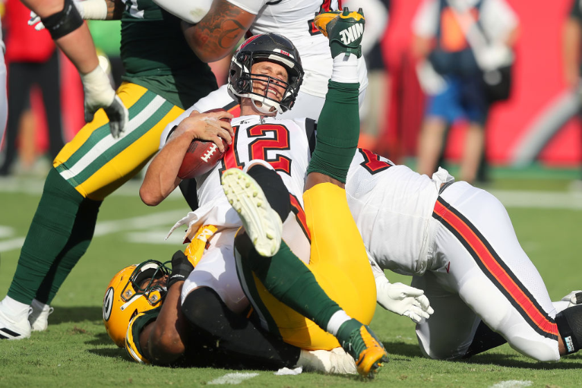Tampa Bay Buccaneers Quarterback Tom Brady (12) is brought down by a Packers defender during the regular season game between the Green Bay Packers and the Tampa Bay Buccaneers 
