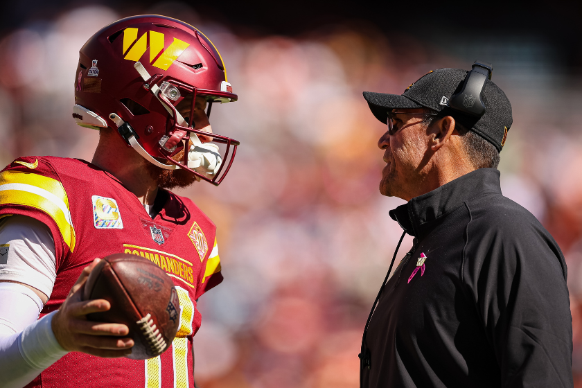 Head coach Ron Rivera of the Washington Commanders speaks with quarterback Carson Wentz #11 during the first half of the game against the Tennessee Titans at FedExField