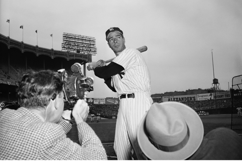 Joe DiMaggio poses for photographs at Yankee Stadium.