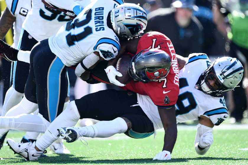 Juston Burris #31 and Frankie Luvu #49 of the Carolina Panthers stop Leonard Fournette #7 of the Tampa Bay Buccaneers from getting a first down in the third quarter