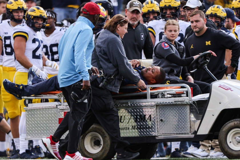 Michigan Wolverines running back coach Mike Hart is carted off of the field during the first half against the Indiana Hoosiers 