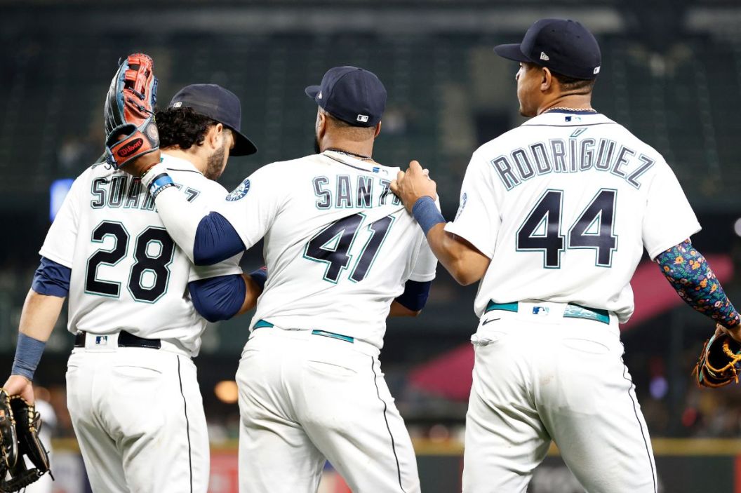 Eugenio Suarez #28, Carlos Santana #41 and Julio Rodriguez #44 of the Seattle Mariners take the field during the game against the Detroit Tigers