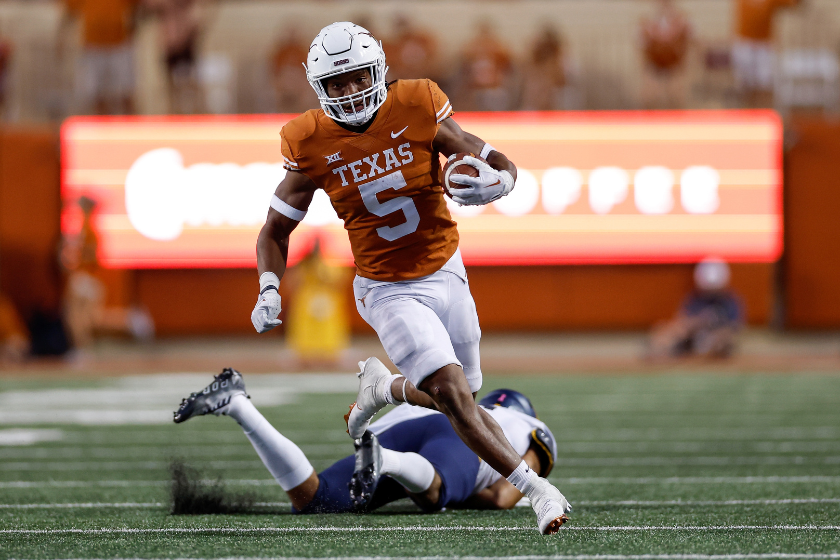 Bijan Robinson #5 of the Texas Longhorns runs past a West Virginia Mountaineers defender in the second half at Darrell K Royal-Texas Memorial Stadium on October 01, 2022 in Austin, Texas.
