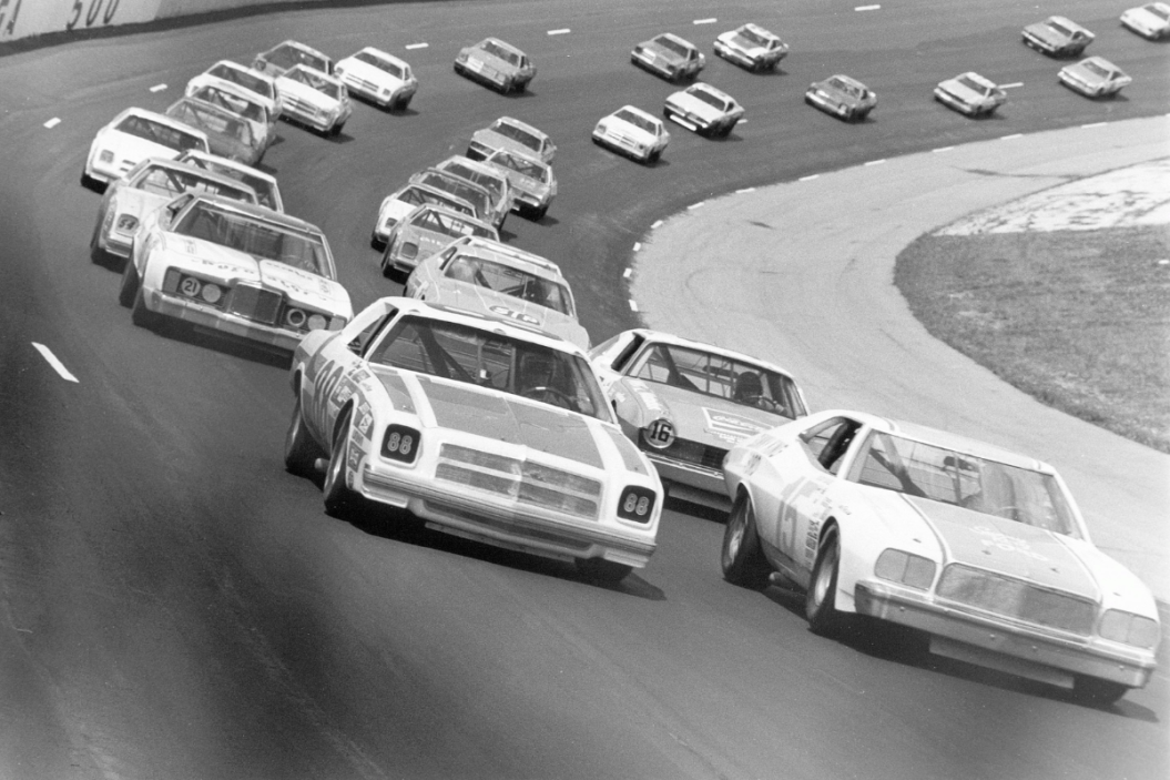 cars driving around talladega superspeedway for 1975 winston 500