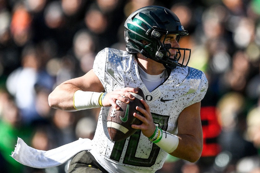 Quarterback Bo Nix #10 of the Oregon Ducks rolls out of the pocket to pass against the Colorado Buffaloes in the first quarter of a game at Folsom Field