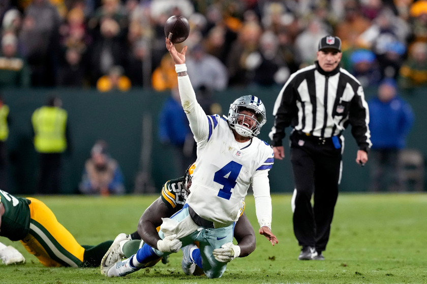 Dak Prescott #4 of the Dallas Cowboys attempts a pass while being tackled by Jarran Reed #90 of the Green Bay Packers during overtime at Lambeau Field