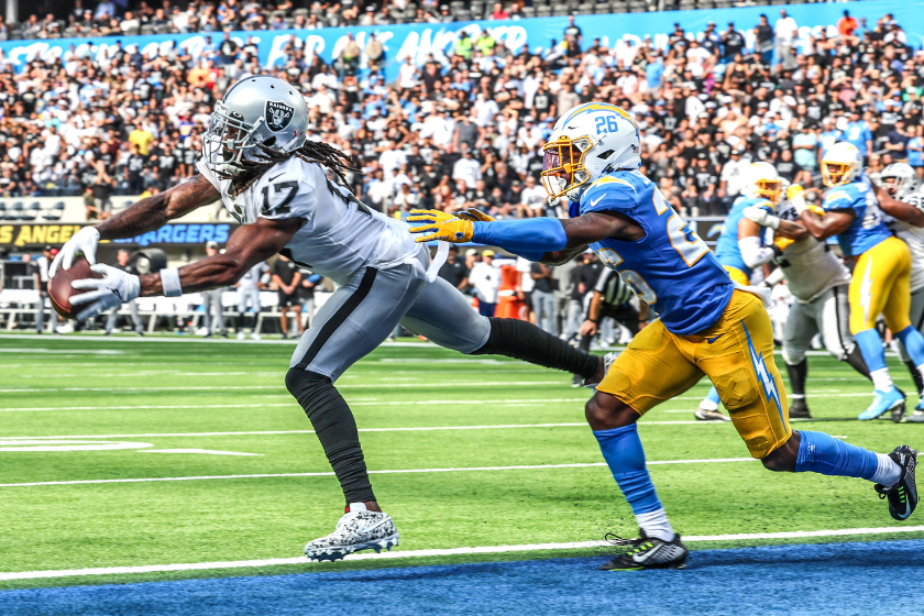 Las Vegas Raiders wide receiver Davante Adams (17) catches a touchdown pass in front of Los Angeles Chargers cornerback Asante Samuel Jr. (26) late in a game.