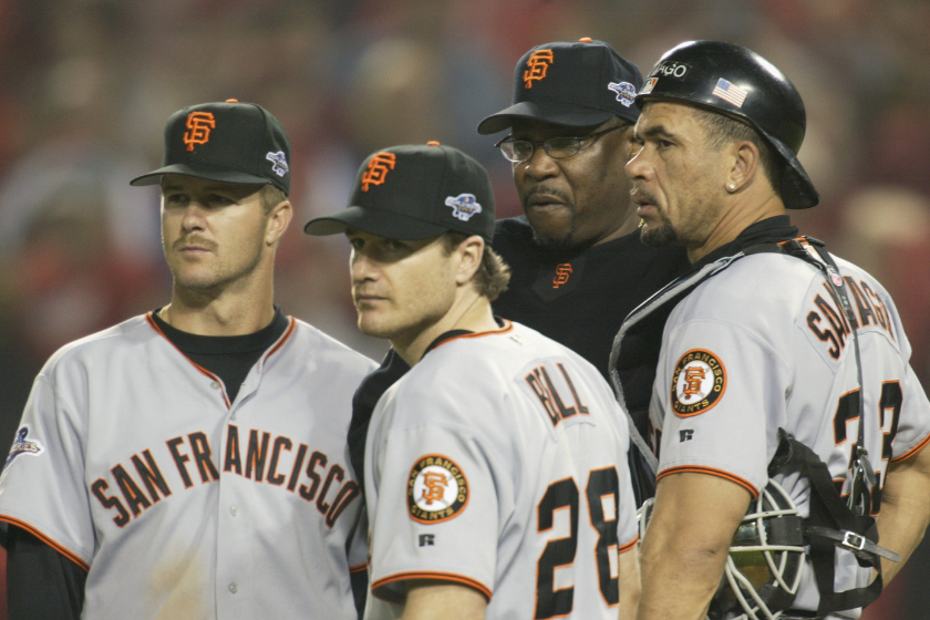 Second baseman Jeff Kent #21, David Bell #28, manager Dusty Baker and catcher Benito Santiago #33 of the San Francisco Giants against look on during game two of the 2002 World Series against the Anaheim Angels