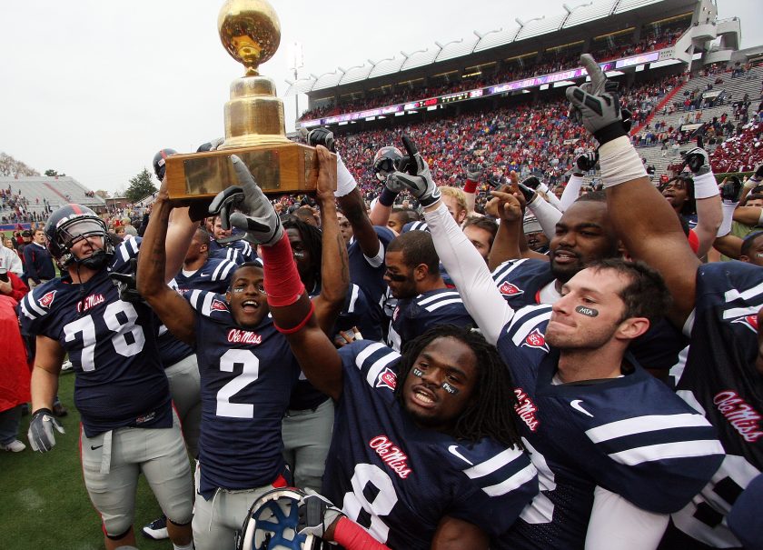 Ole Miss players hold the trophy during the Egg Bowl.
