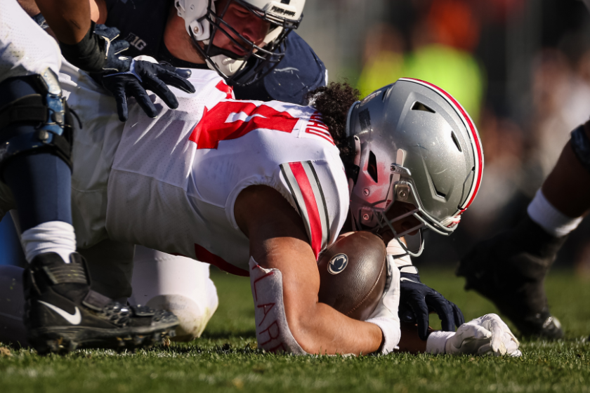 .T. Tuimoloau #44 of the Ohio State Buckeyes causes and recovers a fumble against the Penn State Nittany Lions