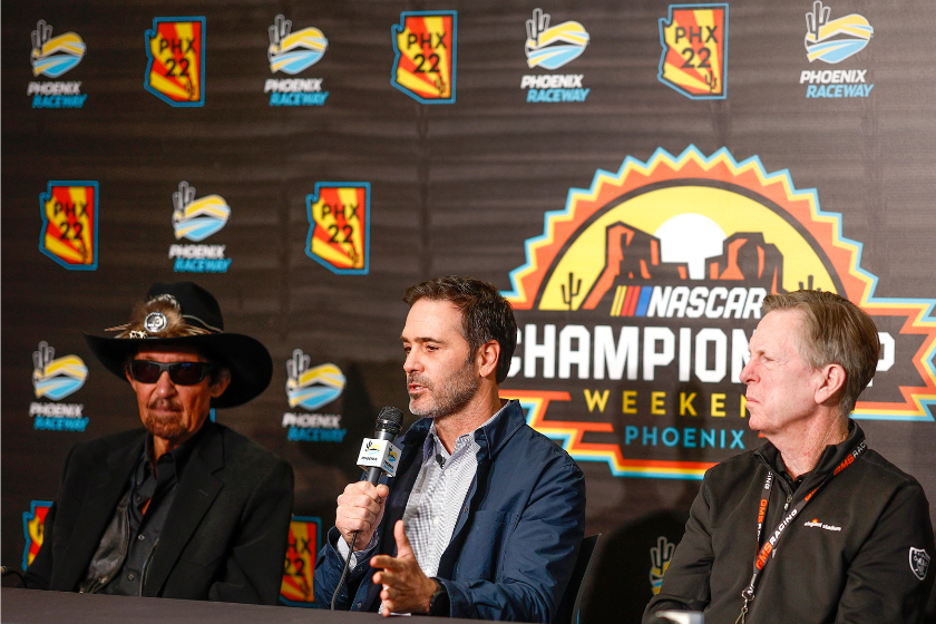 Jimmie Johnson speaks to the media announcing he has invested in an ownership stake in the Petty GMS Motorsports as team owners Richard Petty (L) and Maury Gallagher look on during a press conference at Phoenix Raceway