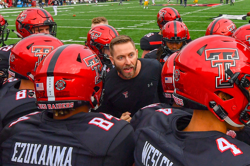 Head coach Kliff Kingsbury of the Texas Tech Red Raiders fires up his team during warm ups before the game against the West Virginia Mountaineers