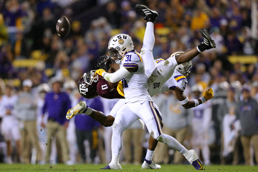 Cameron Lewis #31 and Jay Ward #5 of the LSU Tigers break up a pass intended for Ainias Smith #0 of the Texas A&M Aggies during the first half at Tiger Stadium