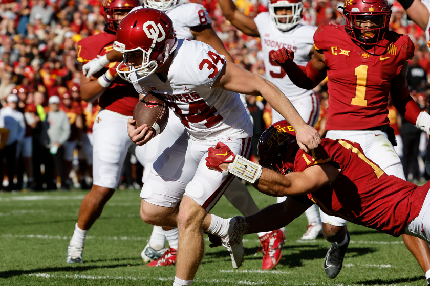 Place kicker Zach Schmit #34 of the Oklahoma Sooners faked a field goal kick and drove the ball into the end zone for a touchdown defensive back Beau Freyler #17 of the Iowa State Cyclones blocks