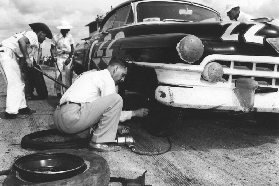 Red Byron along with car owner Raymond Parks (right front), changes tires on his NASCAR Grand National Cadillac during the first running of the Southern 500 at Darlington Raceway in 1950