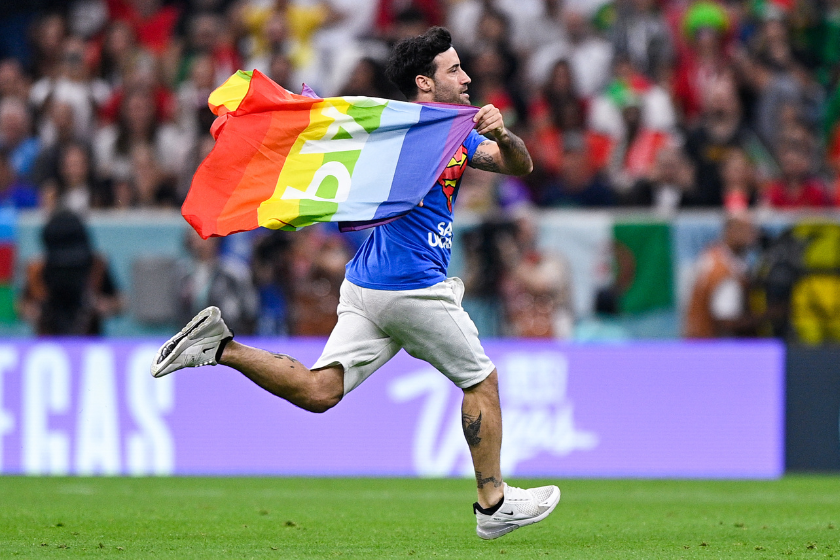 A pitch invader wearing a shirt reading "Save Ukraine" holds a rainbow flag during the Group H - FIFA World Cup Qatar 2022 match between Portugal and Uruguay 