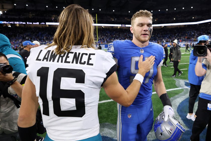Trevor Lawrence #16 of the Jacksonville Jaguars greets Aidan Hutchinson #97 of the Detroit Lions on the field after the game at Ford Field