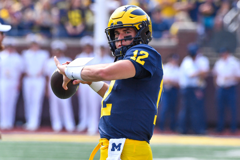 Cade McNamara #12 of the Michigan Wolverines warms up before a college football game against the Connecticut Huskies