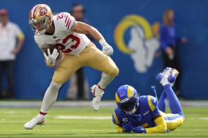Christian McCaffrey #23 of the San Francisco 49ers runs with the ball as Jalen Ramsey #5 of the Los Angeles Rams defends during the first half at SoFi Stadium