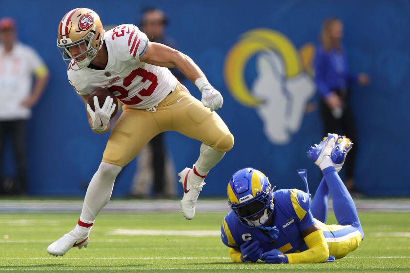 Christian McCaffrey #23 of the San Francisco 49ers runs with the ball as Jalen Ramsey #5 of the Los Angeles Rams defends during the first half at SoFi Stadium