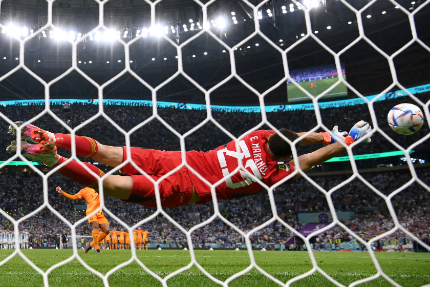 In this photo taken from a remote camera from behind the goal) Emiliano Martinez of Argentina makes a save on the first penalty by Virgil Van Dijk of Netherlands during the FIFA World Cup Qatar 2022 