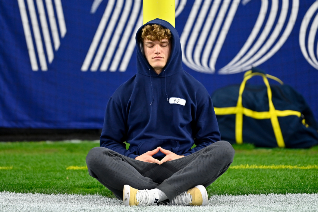 Quarterback J.J. McCarthy #9 of the Michigan Wolverines meditates before the College Football Playoff Semifinal Fiesta Bowl football game against the TCU Horned Frogs at State Farm Stadium