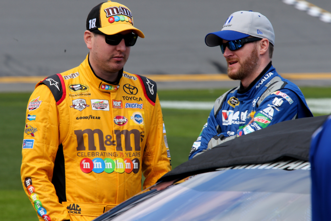 Kyle Busch talks with Dale Earnhardt Jr. on the grid during qualifying for the 2016 Daytona 500 at Daytona International Speedway