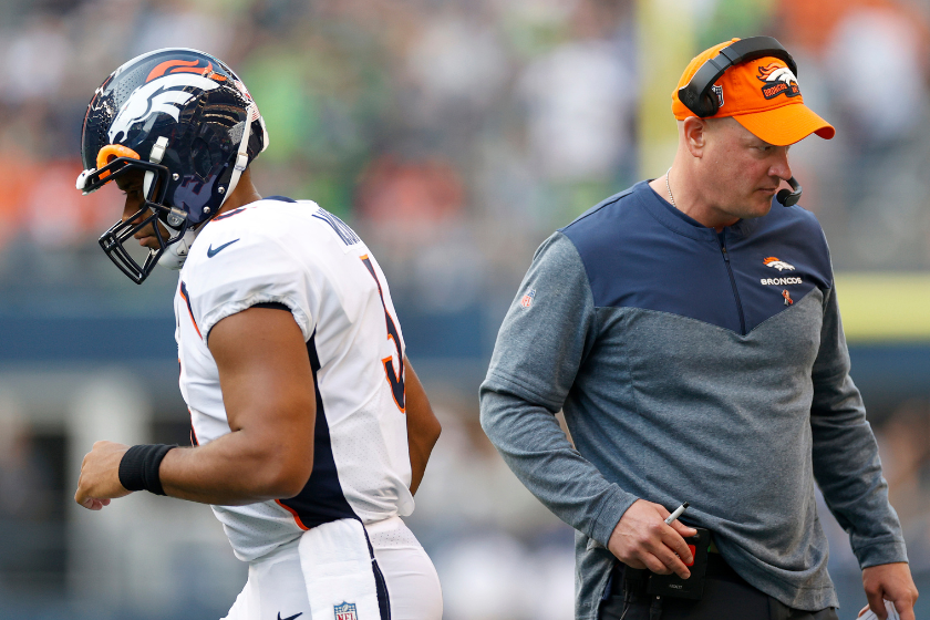 Russell Wilson #3 and head coach Nathaniel Hackett of the Denver Broncos pass each other during the first quarter against the Seattle Seahawks at Lumen Field
