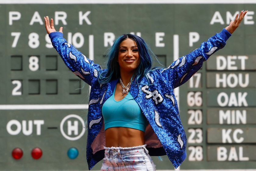 Six time WWE Women's Champion Sasha Banks holds up her arms after throwing out the first pitch before the game between the Boston Red Sox and the Chicago White Sox