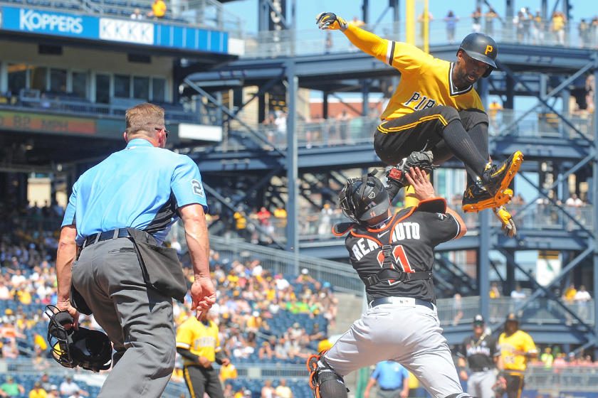 Andrew McCutchen #22 of the Pittsburgh Pirates is tagged out at home plate by J.T. Realmuto #11 of the Miami Marlins as part of a double play in the sixth inning during the game PNC Park 