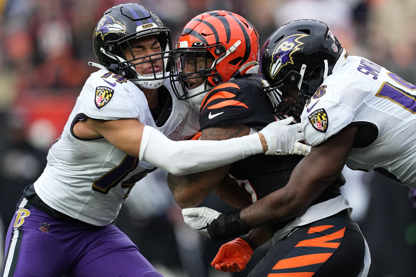 Kyle Hamilton #14 and Roquan Smith #18 of the Baltimore Ravens tackle Joe Mixon #28 of the Cincinnati Bengals during the second quarter at Paycor Stadium