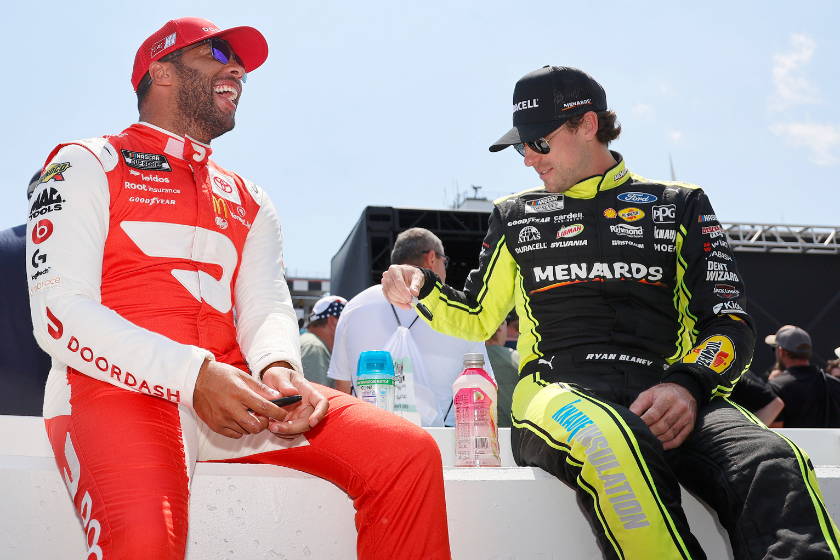 Bubba Wallace and Ryan Blaney share a laugh on the grid prior to the NASCAR Cup Series M&M's Fan Appreciation 400 at Pocono Raceway on July 24, 2022 in Long Pond, Pennsylvania