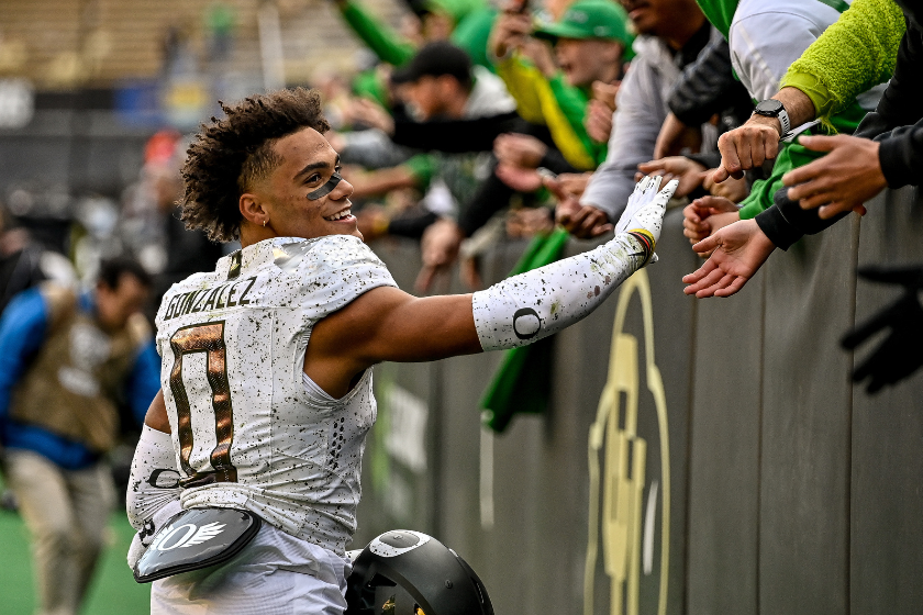 Defensive back Christian Gonzalez #0 of the Oregon Ducks gives high fives to supporters after a game against the Colorado Buffaloes at Folsom Field 