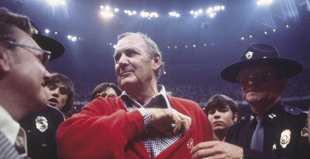 UNDATED: Coach of the Alabama Crimson Tide, Bear Bryant, talks to fans as he is escorted off the field by police circa 1980's.