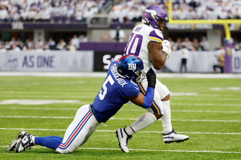 Kayvon Thibodeaux #5 of the New York Giants tackles C.J. Ham #30 of the Minnesota Vikings during the first quarter at U.S. Bank Stadium