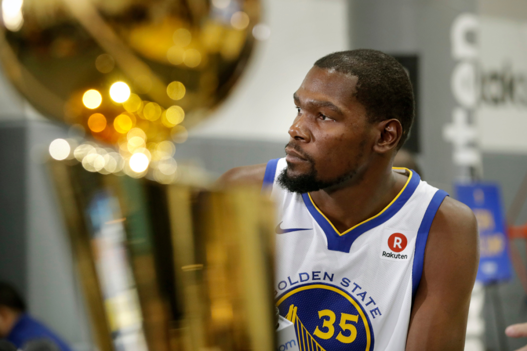 Warriors' Kevin Durant near the Larry O'Brien championship trophy during 2017 media day for the NBA's Golden State Warriors