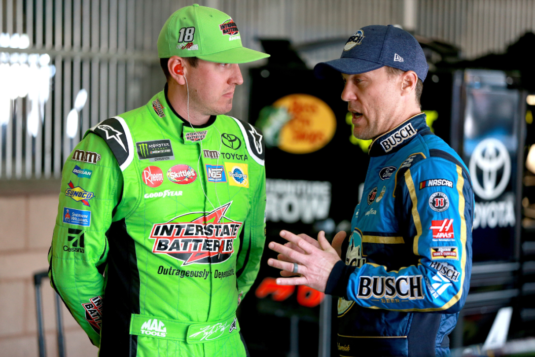 Kyle Busch and Kevin Harvick talk in the garage during practice for the Monster Energy NASCAR Cup Series Auto Club 400 at Auto Club Speedway on March 17, 2018 in Fontana, California