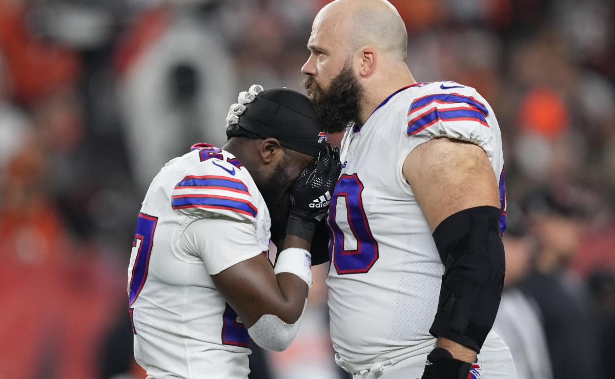 Tre'Davious White #27 and Mitch Morse #60 of the Buffalo Bills react to teammate Damar Hamlin #3 collapsing after making a tackle against the Cincinnati Bengals during the first quarter