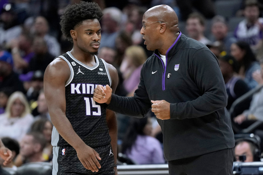 Head coach Mike Brown of the Sacramento Kings talks with his player Davion Mitchell #15 against the LA Clippers at the end of the third quarter of an NBA basketball game at Golden 1 Center