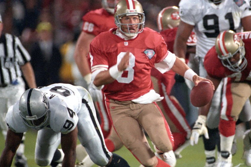Steve Young scrambles with the ball.