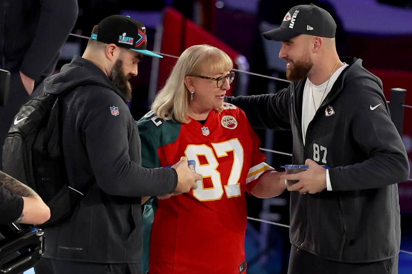 Mother Donna Kelce (C) gives cookies to her son's Jason Kelce (L) #62 of the Philadelphia Eagles and Travis Kelce (R) #87 of the Kansas City Chiefs during Super Bowl LVII Opening Night presented by Fast Twitch at Footprint Center