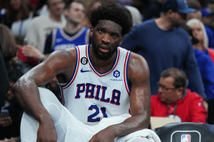 Joel Embiid #21 of the Philadelphia 76ers looks on from the bench against the Denver Nuggets at the Wells Fargo Center